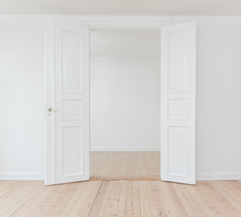 An empty home with white french doors.