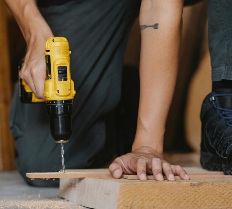 Construction worker using an electric drill.