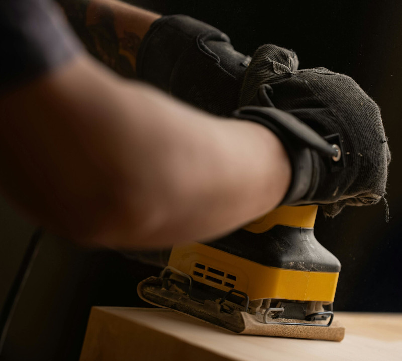 Construction worker using a rotary sander.