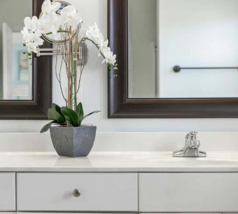A vase of flowers on a bathroom counter.