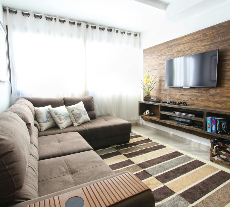 A small family room with a wall mounted television and a sofa.